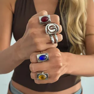 Close-up of vintage engraved silver rings with colorful red, blue, and yellow gemstones
