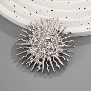 Vue détaillée d'une broche en relief de déesse du soleil argentée aux traits fins.