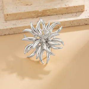 Detailed macro view of a silver-toned firework flame alloy brooch with 3D design texture