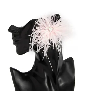 Détail de boucles d'oreilles élégantes en plumes roses avec strass brillant