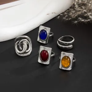 Macro view of vintage rings with colored gemstones and textured silver finish.