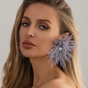 Élégante femme blonde portant des boucles d'oreilles en plumes lavande et cristal