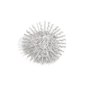 Vue détaillée d'une broche en relief déesse du soleil argentée aux traits délicats.
