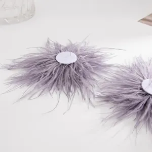 Vue détaillée de boucles d'oreilles élégantes en plumes lavande sur fond blanc