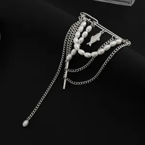 Detail van zilveren kettingbroche met witte imitatieparels en vis