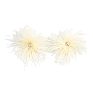 Vue détaillée de boucles d'oreilles en plumes crème avec un strass étincelant au centre