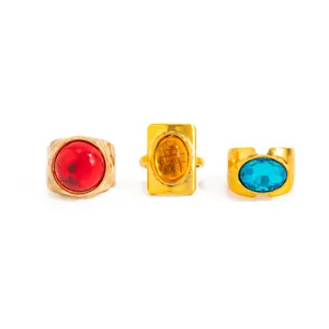 Detailed view of three French vintage rings with vibrant red, amber, and blue gems
