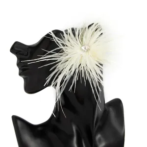 Gros plan sur une boucle d'oreille en plumes blanches avec un strass étincelant au centre