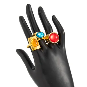 Macro view of vintage French chunky gold rings with colorful gemstones on black hand