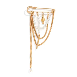 Gedetailleerd overzicht van gouden kwastjesbroche met imitatieparels en creatieve visbedel.