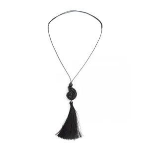 Detail of black adjustable long necklace featuring shell pendant and elegant tassel