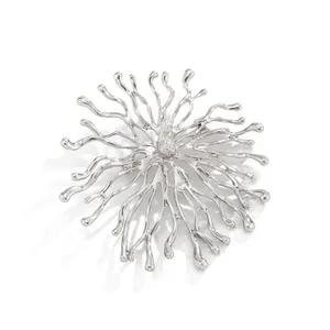 Gros plan détaillé d'une broche déesse du soleil en argent avec des bras de corail radieux