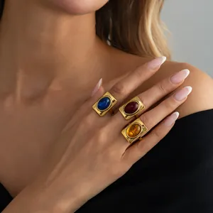 Close-up detail of model wearing three French retro square rings with vibrant colorful gemstones