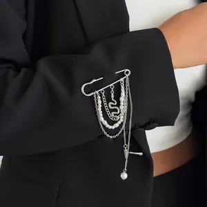 Detail van zilveren veiligheidsspeld broche met parels en slangenketting
