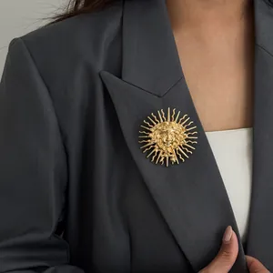 Élégante broche vintage en relief déesse du soleil dorée sur un blazer gris