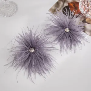 Boucles d'oreilles élégantes en plumes violettes avec un strass étincelant au centre