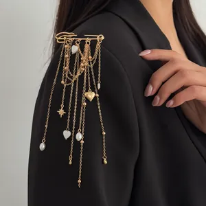 Detailed view of a golden safety pin brooch with cascading heart and pearl tassels.
