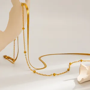 Détail macro de la chaîne de corps dorée en acier inoxydable avec perles et mailles