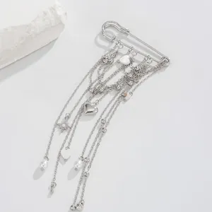 Detailed view of a silver tassel brooch with heart and star charms on a white background.