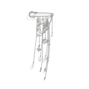 Detailed view of silver safety pin brooch featuring long tassels and heart charms
