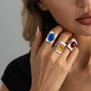 Close-up of French vintage rectangular rings with colorful gems on model's hand.