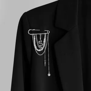 Detailopname van zilveren kwastje veiligheidsspeld broche met parels en slang hanger