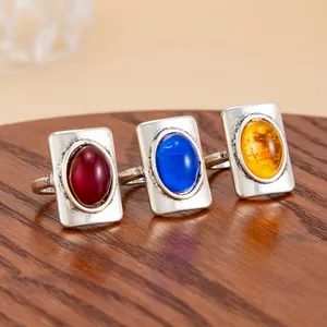 Detailed view of vintage French rectangular rings featuring colorful oval gemstones on wood