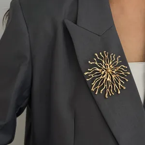Unique gold sunburst coral brooch pin on grey blazer for creative fashion styling