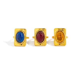 Detailed view of three vintage gold rings with blue, red, and amber oval gemstones