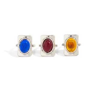 Detailed view of three vintage-style rings with blue, red, and amber resin stones.