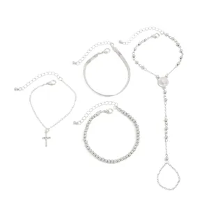 Vista detallada del conjunto de joyas plateadas con colgante de cruz y pulseras de serpiente