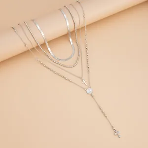 Vista detallada del collar de cadena de plata con colgante de cruz y cadena de serpiente plana