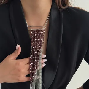 Primo piano della collana con perline di cristallo e spilla da balia su blazer nero