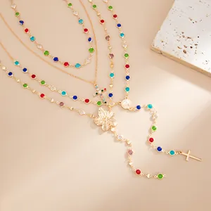 Detalle de cuentas de cristal de colores y colgante de flor dorada en collar de varias capas