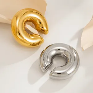 Macro detail of high-gloss gold and silver molten C-shaped stainless steel ear clips