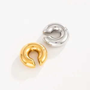 Detailed macro view of polished gold and silver C-shaped stainless steel lava ear cuffs