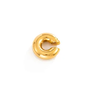 Close-up of a chunky gold-tone C-shaped stainless steel ear cuff with a polished finish