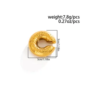 Detailed view of gold C-shaped stainless steel ear cuff with melted lava texture.