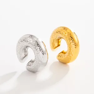 Detail view of gold and silver textured lava style C-shaped stainless steel ear cuffs