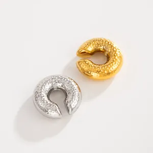 Detailed view of hammered texture on gold and silver stainless steel C-shaped ear cuffs
