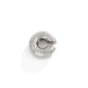 Close-up of a silver C-shaped stainless steel ear cuff with hammered lava texture