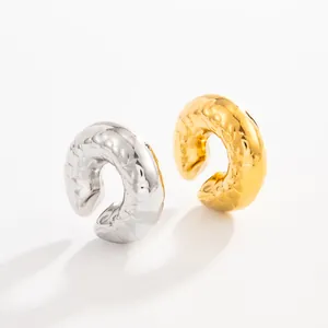 Detailed close-up of C-shaped lava textured stainless steel ear cuffs in gold and silver finish