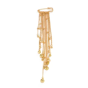 Exquisite detail of a golden multi-layer tassel chain brooch featuring polished metallic spheres.