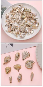 Close-up detail of various golden acrylic shell charms for DIY jewelry and crafts.