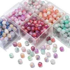 Gros plan de perles en verre craquelé colorées dans des boîtes transparentes