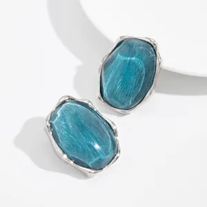 Dettaglio di anelli d'argento con pietre preziose blu e trama a onde d'acqua.