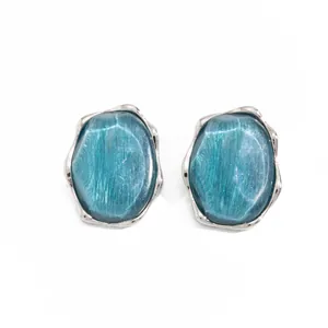 Primo piano di un elegante anello geometrico in argento con pietra blu ondulata