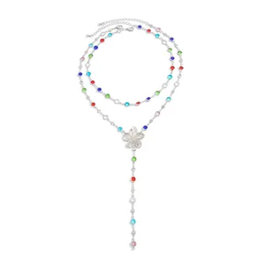 Primer plano del collar en Y plateado con cristales de colores y detalle de flor