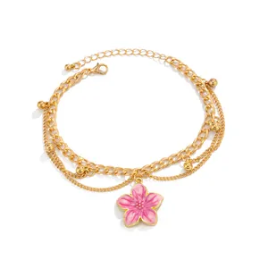 Detailed view of a gold double-layer anklet featuring a pink enamel flower pendant