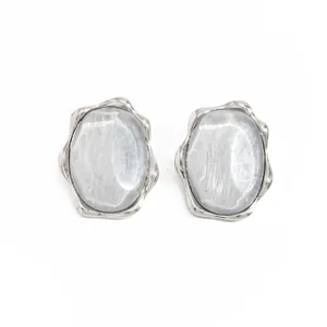 Primo piano di un anello d'argento effetto acqua con gemma grigia ovale per un look moderno.
